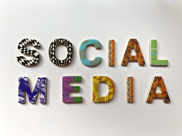 The words "social media" spelt using colourful pieces like a puzzle. Photo by Merakist on Unsplash.